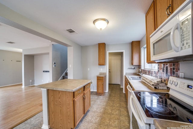 9843 Barhill Bay, San Antonio, TX 78245 - kitchen with white appliances, brown cabinets, and light countertops