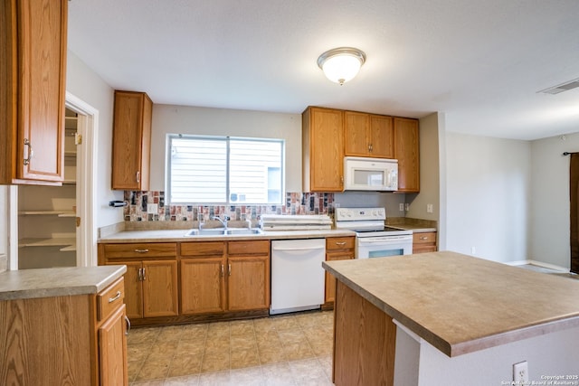 9843 Barhill Bay, San Antonio, TX 78245 - kitchen featuring white appliances, a sink, brown cabinets, tasteful backsplash, and light countertops