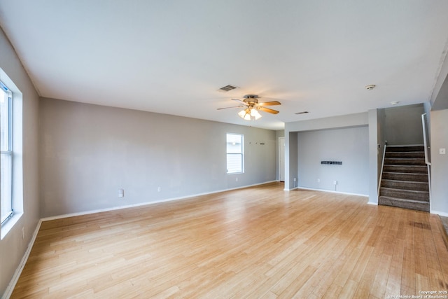 9843 Barhill Bay, San Antonio, TX 78245 - unfurnished living room featuring stairway, a ceiling fan, light wood-type flooring, and baseboards