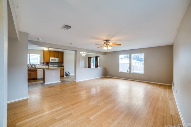 9843 Barhill Bay, San Antonio, TX 78245 - unfurnished living room with healthy amount of natural light, a ceiling fan, and light wood-style floors