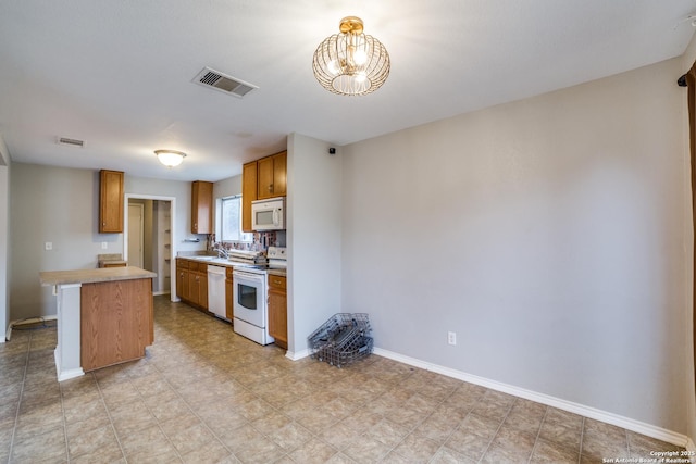 9843 Barhill Bay, San Antonio, TX 78245 - kitchen featuring white appliances, light countertops, a sink, brown cabinets, and baseboards