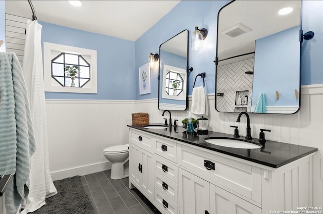 3719 Summer Breeze, San Antonio, TX 78253 - bathroom with a wainscoted wall, double vanity, toilet, curtained shower, and tile patterned flooring