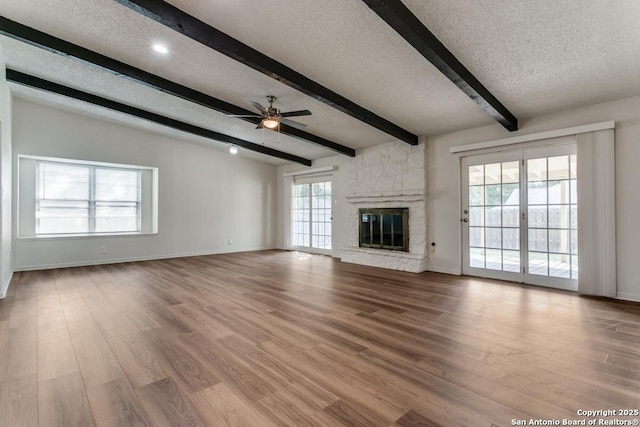 6419 Ridge Tree, San Antonio, TX 78233 - unfurnished living room with beamed ceiling, plenty of natural light, a ceiling fan, a textured ceiling, and baseboards
