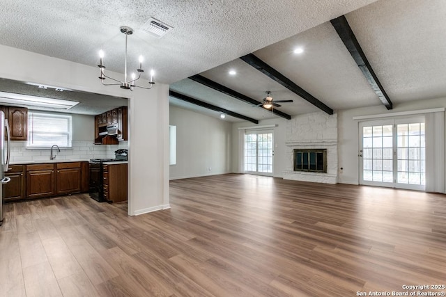6419 Ridge Tree, San Antonio, TX 78233 - unfurnished living room featuring a ceiling fan, a sink, beamed ceiling, a chandelier, and light wood-style floors