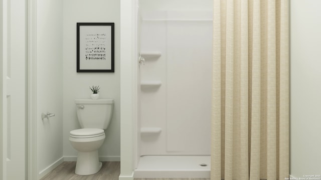 5650 Azure Aly, San Antonio, TX 78223 - bathroom featuring baseboards, a shower stall, wood finished floors, and toilet