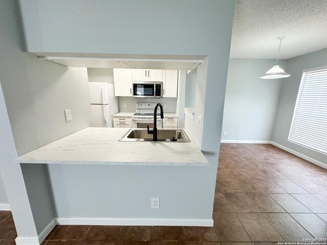 11311 Sir Winston Unit 607, San Antonio, TX 78216 - kitchen with white appliances, a sink, white cabinetry, a peninsula, and baseboards