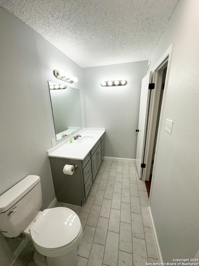 11311 Sir Winston Unit 607, San Antonio, TX 78216 - bathroom with toilet, a textured ceiling, vanity, and baseboards