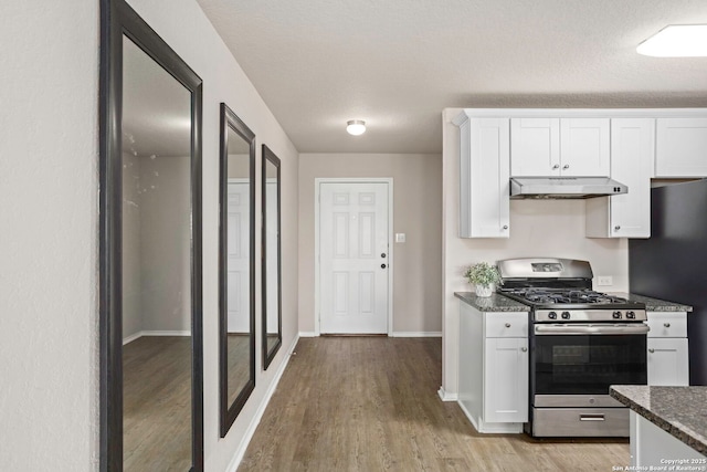 31553 Acacia Vis, Bulverde, TX 78163 - kitchen featuring gas range, under cabinet range hood, light wood-style flooring, white cabinets, and freestanding refrigerator