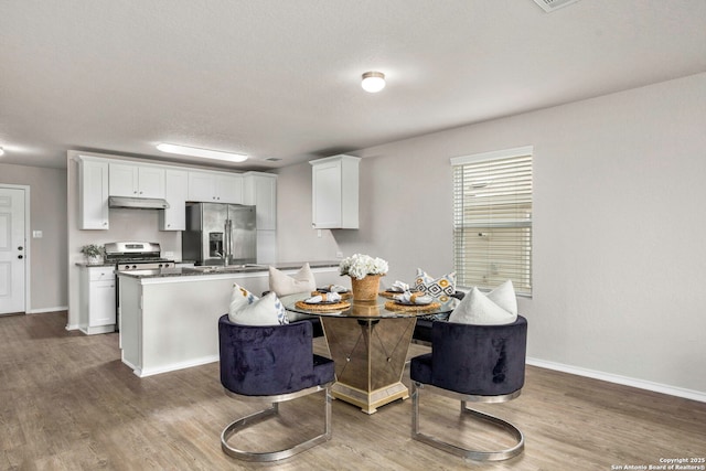 31553 Acacia Vis, Bulverde, TX 78163 - dining space featuring wood finished floors, baseboards, a textured ceiling, and breakfast area