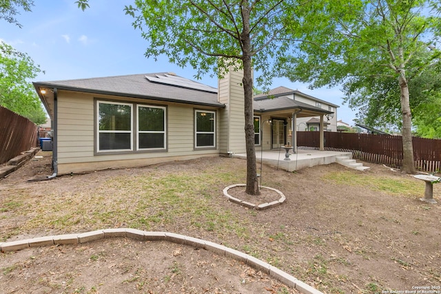 15311 Spring Rock, San Antonio, TX 78247 - rear view of property with a patio area, solar panels, a chimney, and a shingled roof