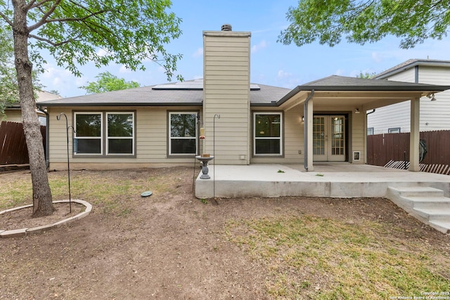 15311 Spring Rock, San Antonio, TX 78247 - rear view of house with french doors, a patio area, roof mounted solar panels, and a chimney