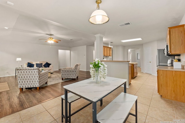 15311 Spring Rock, San Antonio, TX 78247 - dining space featuring arched walkways, light tile patterned floors, ornate columns, a ceiling fan, and baseboards