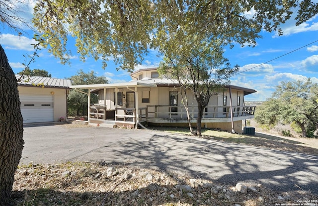 8060 Prue, San Antonio, TX 78249 - view of front of property with a porch, an attached garage, cooling unit, metal roof, and a standing seam roof