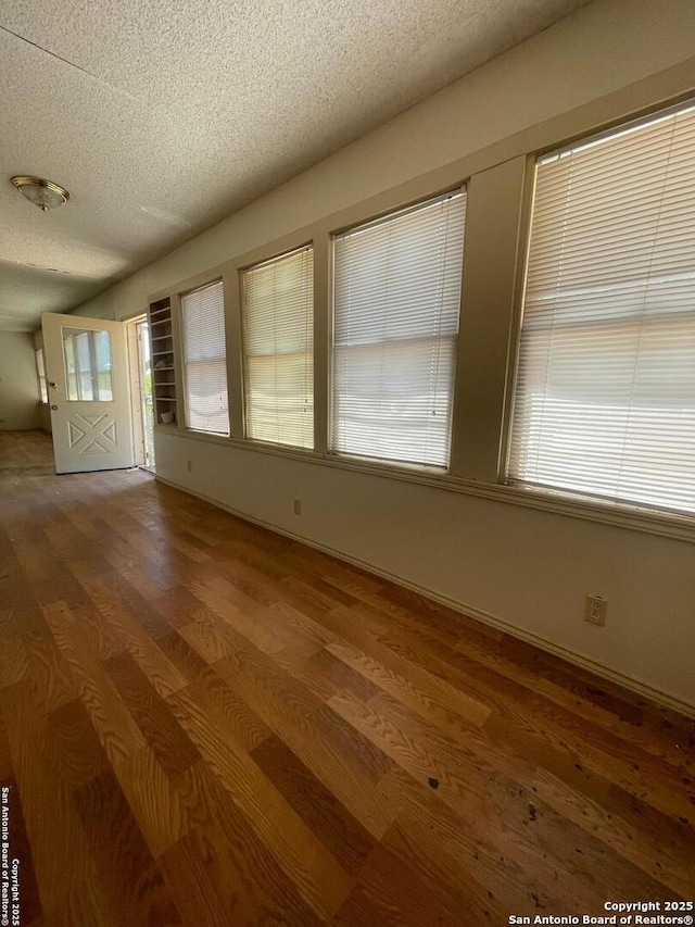 8439 Gardner, San Antonio, TX 78263 - spare room with wood finished floors and a textured ceiling