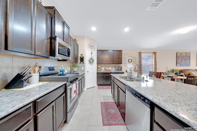 5903 Overture Dawn, San Antonio, TX 78252 - kitchen with appliances with stainless steel finishes, a sink, light tile patterned flooring, decorative backsplash, and recessed lighting