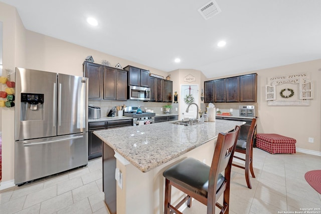 5903 Overture Dawn, San Antonio, TX 78252 - kitchen with stainless steel appliances, a sink, dark brown cabinets, light tile patterned flooring, and recessed lighting