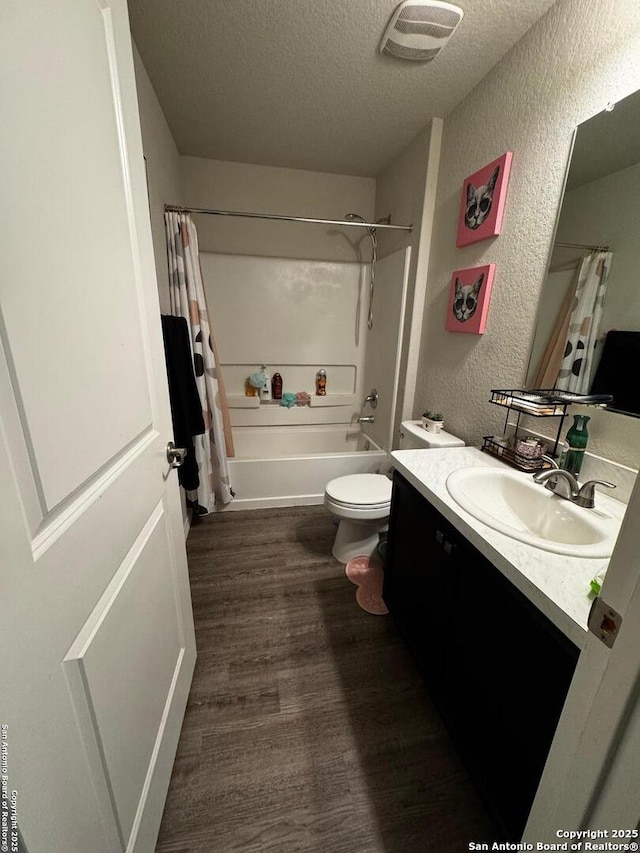 6914 Cozy, San Antonio, TX 78218 - bathroom with a textured wall, a textured ceiling, wood finished floors, vanity, and toilet