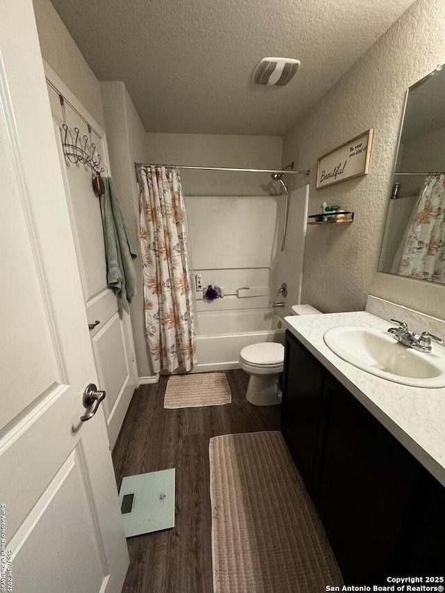 6914 Cozy, San Antonio, TX 78218 - bathroom featuring a textured ceiling, wood finished floors, a textured wall, vanity, and toilet