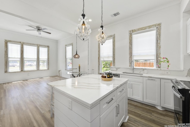 1526 Saint Marys, San Antonio, TX 78210 - kitchen with a sink, black / electric stove, a kitchen island, crown molding, and dark wood finished floors