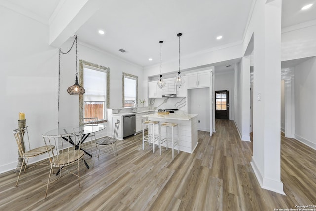 1526 Saint Marys, San Antonio, TX 78210 - kitchen with stainless steel dishwasher, light countertops, crown molding, white cabinetry, and a center island