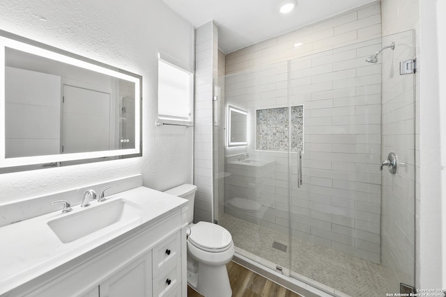 1526 Saint Marys, San Antonio, TX 78210 - bathroom with toilet, wood finished floors, a textured wall, a shower stall, and vanity