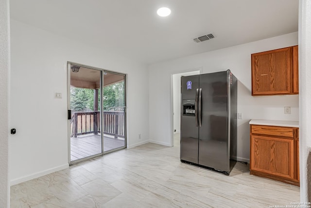 7111 Hallie, San Antonio, TX 78227 - kitchen with stainless steel fridge, brown cabinets, light countertops, and baseboards