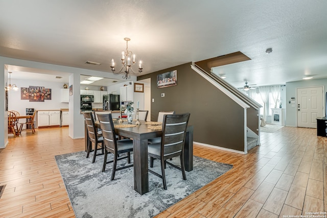 6459 Marlin Flts, San Antonio, TX 78244 - dining area featuring a chandelier, light wood-style floors, stairs, and baseboards