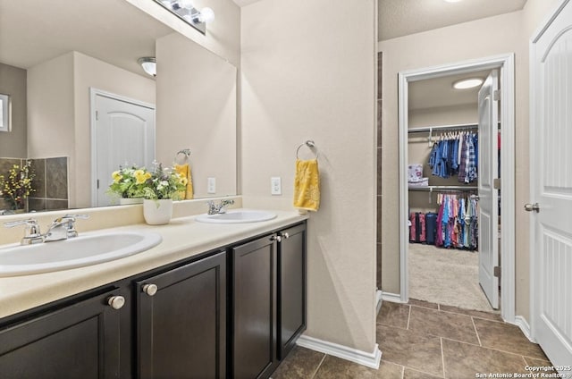 8940 Hickman Park, San Antonio, TX 78254 - full bath with double vanity, a walk in closet, baseboards, and tile patterned floors