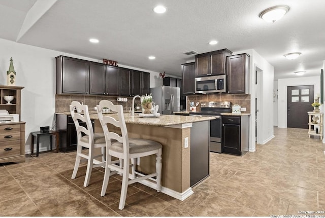 8940 Hickman Park, San Antonio, TX 78254 - kitchen featuring stainless steel appliances, decorative backsplash, a kitchen breakfast bar, a center island with sink, and recessed lighting