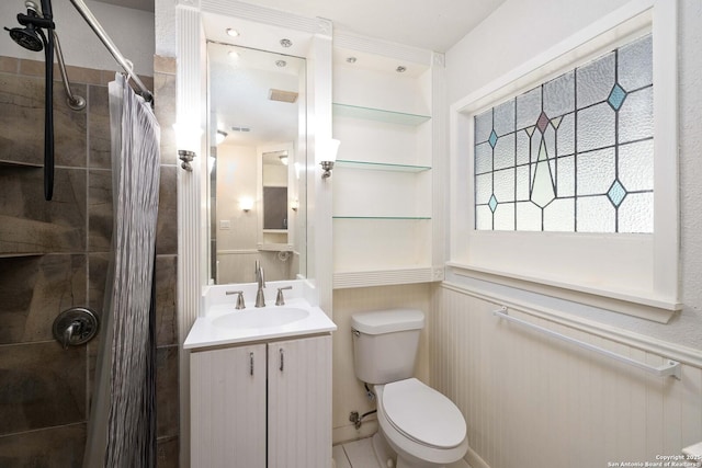 3702 La Sabre Dr, San Antonio, TX 78218 - full bath with a tile shower, toilet, vanity, and a wainscoted wall