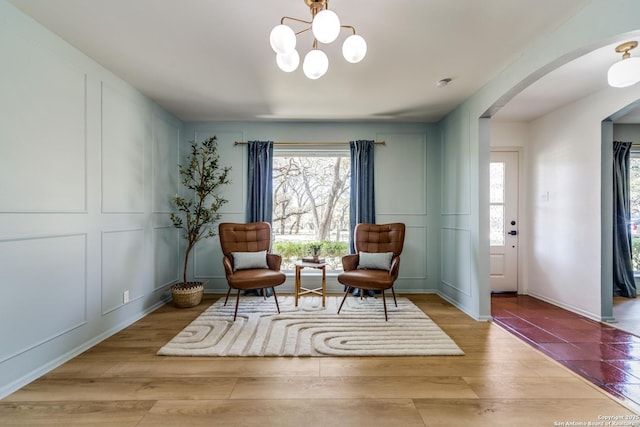 146 Canyon Oaks, Hollywood Park, TX 78232 - living area featuring arched walkways, wood finished floors, a chandelier, and a decorative wall