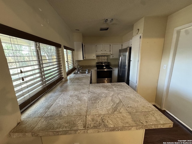 6917 Deep Lk, San Antonio, TX 78244 - kitchen with appliances with stainless steel finishes, a sink, a textured ceiling, white cabinets, and under cabinet range hood