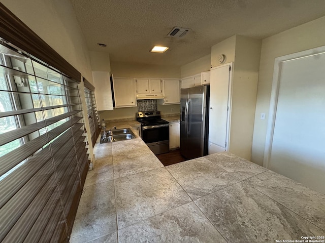 6917 Deep Lk, San Antonio, TX 78244 - kitchen featuring stainless steel appliances, a sink, white cabinets, a textured ceiling, and under cabinet range hood