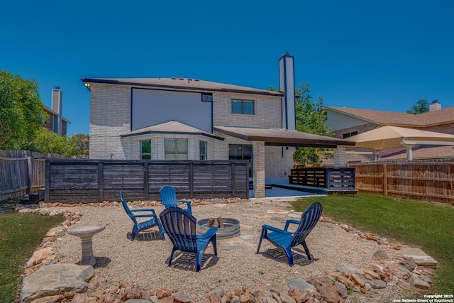 2310 Ruby Oaks, San Antonio, TX 78232 - rear view of house with brick siding, a fire pit, and a fenced backyard