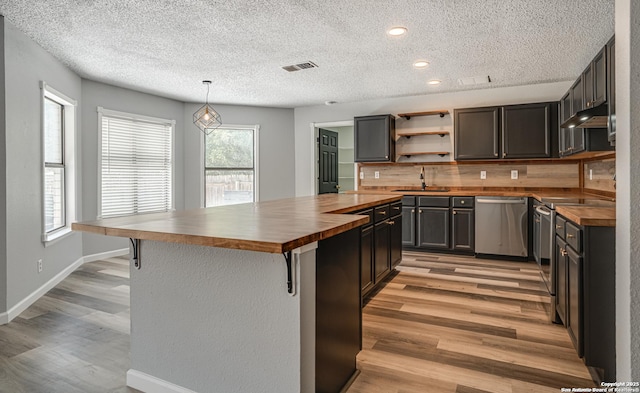 2310 Ruby Oaks, San Antonio, TX 78232 - kitchen with wooden counters, dishwasher, light wood-type flooring, healthy amount of natural light, and a textured ceiling