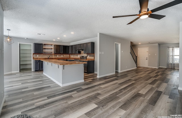 2310 Ruby Oaks, San Antonio, TX 78232 - kitchen featuring wooden counters, open floor plan, a textured ceiling, open shelves, and recessed lighting