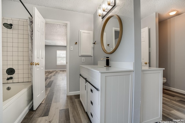 2310 Ruby Oaks, San Antonio, TX 78232 - full bathroom featuring a textured ceiling, vanity, wood finished floors, toilet, and shower / bath combo with shower curtain
