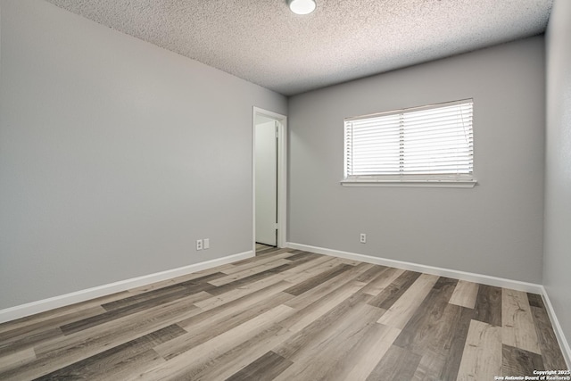 2310 Ruby Oaks, San Antonio, TX 78232 - unfurnished room featuring a textured ceiling, wood finished floors, and baseboards