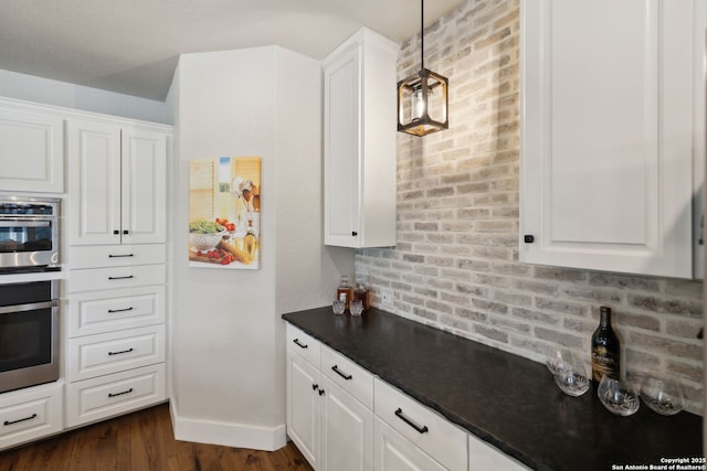 2803 River Way, Spring Branch, TX 78070 - kitchen with white cabinetry, dark countertops, dark wood finished floors, and baseboards