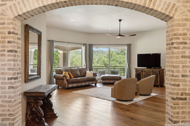 2803 River Way, Spring Branch, TX 78070 - living room featuring ceiling fan, hardwood / wood-style floors, a textured ceiling, arched walkways, and recessed lighting