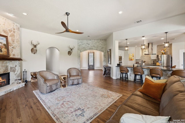 2803 River Way, Spring Branch, TX 78070 - living area featuring arched walkways, a ceiling fan, dark wood finished floors, a fireplace, and recessed lighting
