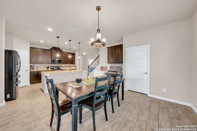 2015 Sisyphus, San Antonio, TX 78245 - dining space featuring a chandelier, light wood-style flooring, baseboards, recessed lighting, and stairs