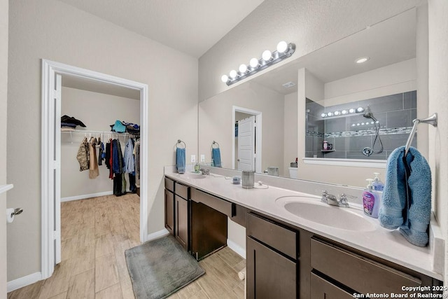 2015 Sisyphus, San Antonio, TX 78245 - bathroom with double vanity, a walk in shower, a spacious closet, and baseboards