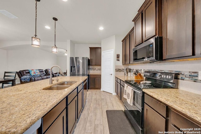 2015 Sisyphus, San Antonio, TX 78245 - kitchen with appliances with stainless steel finishes, a sink, decorative backsplash, dark brown cabinets, and recessed lighting