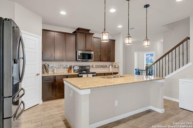 2015 Sisyphus, San Antonio, TX 78245 - kitchen with appliances with stainless steel finishes, a sink, light wood-type flooring, dark brown cabinets, and recessed lighting