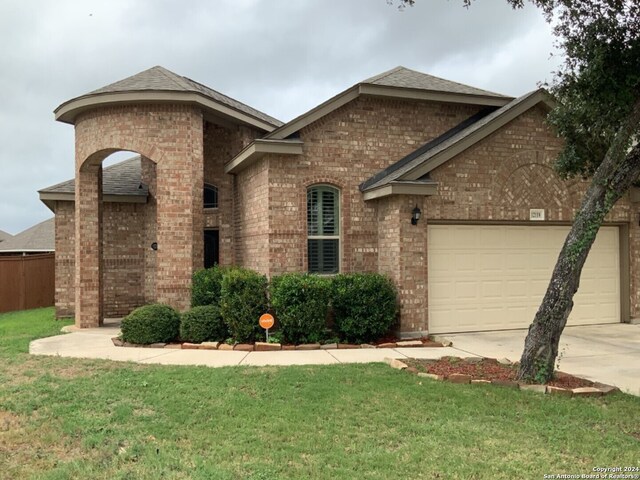 12118 Fort Leaton, San Antonio, TX 78254 - view of front of house with brick siding, driveway, a garage, a front yard, and a shingled roof