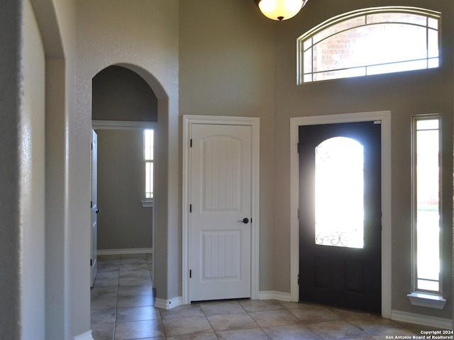 12118 Fort Leaton, San Antonio, TX 78254 - foyer entrance featuring arched walkways, tile patterned floors, a high ceiling, and baseboards