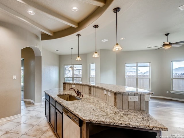 12118 Fort Leaton, San Antonio, TX 78254 - kitchen featuring dishwasher, a sink, a large island with sink, arched walkways, and beamed ceiling