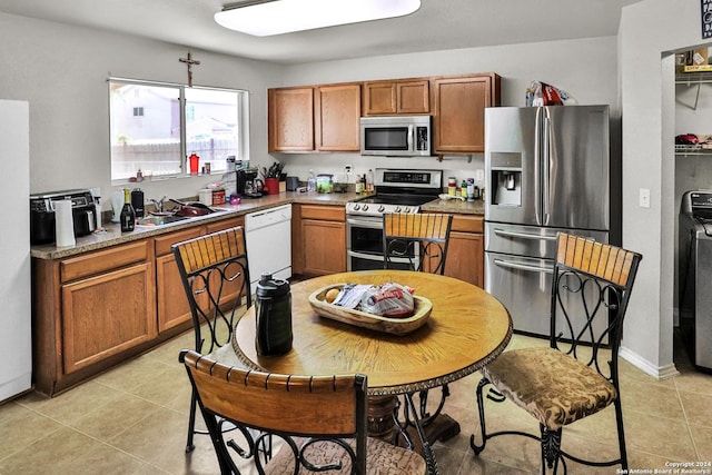 5414 Kensington Run, San Antonio, TX 78228 - kitchen with stainless steel appliances, a sink, light tile patterned floors, light countertops, and brown cabinets