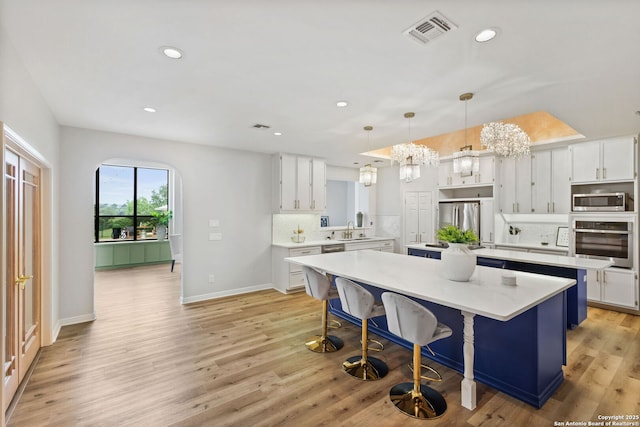 625 Paseo Canada, San Antonio, TX 78232 - kitchen featuring stainless steel appliances, a center island, light countertops, decorative backsplash, and white cabinetry